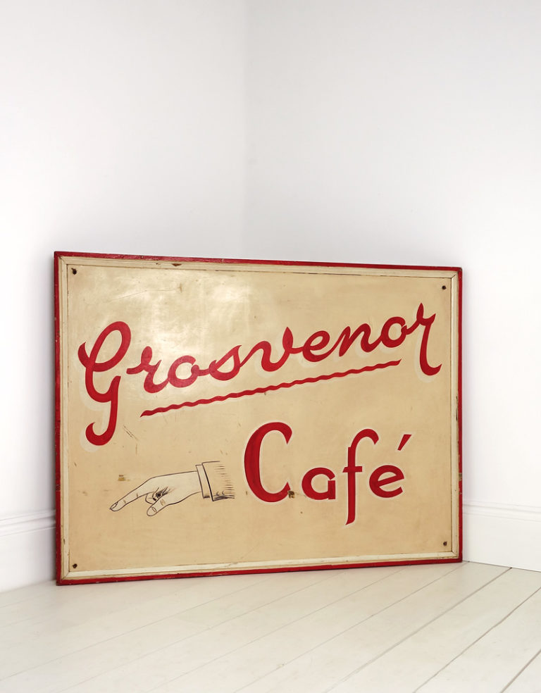 A large hand painted sign “Grosvenor Cafe” with a finger pointing hand illustration. Circa 1950’s.