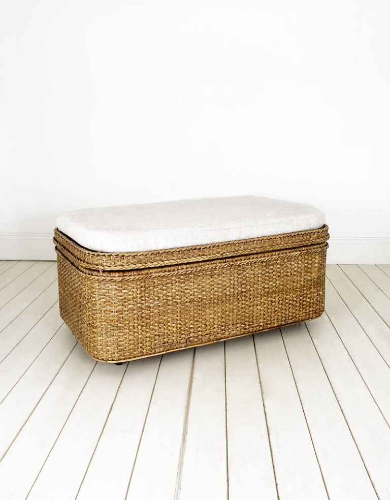 Large rattan storage chest with a cushion and detachable shelf.