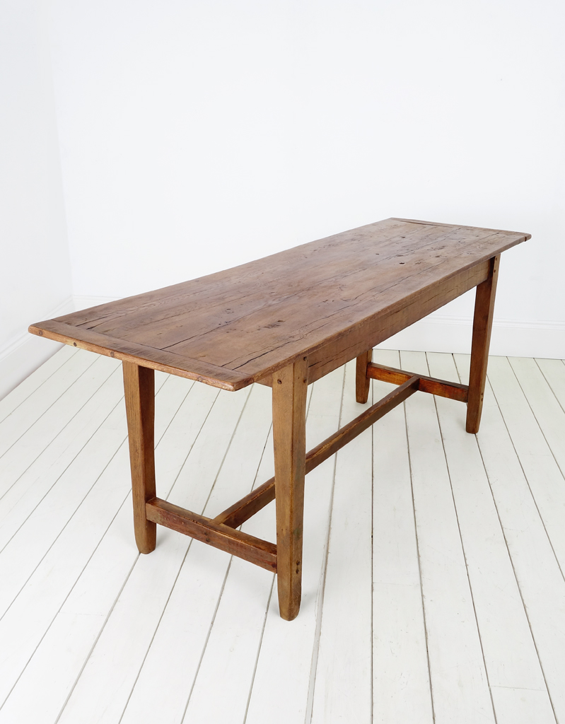 Slim oak plank top table with cleated ends and an overhanging top.