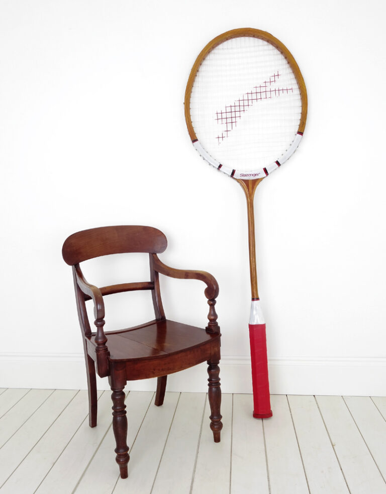 An oversized wooden Slazenger tennis racket.